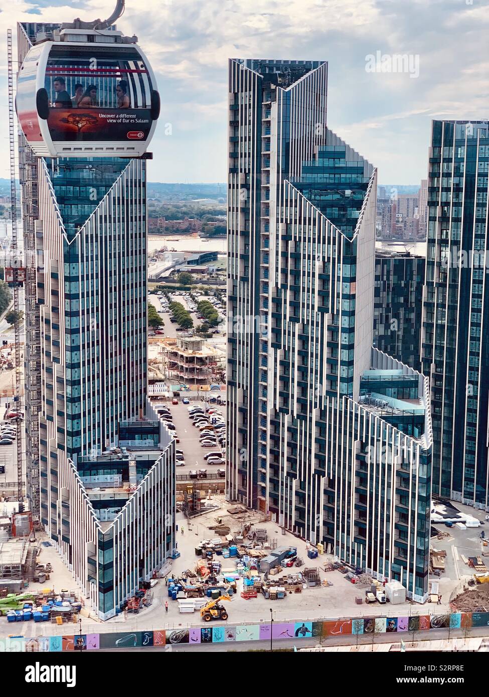 Greenwich,UK - 5 July 2019: Emirates air line cable car cabin travels past spectacular high rise buildings on the Greenwich peninsula. - Smartphone Captured Stock Image