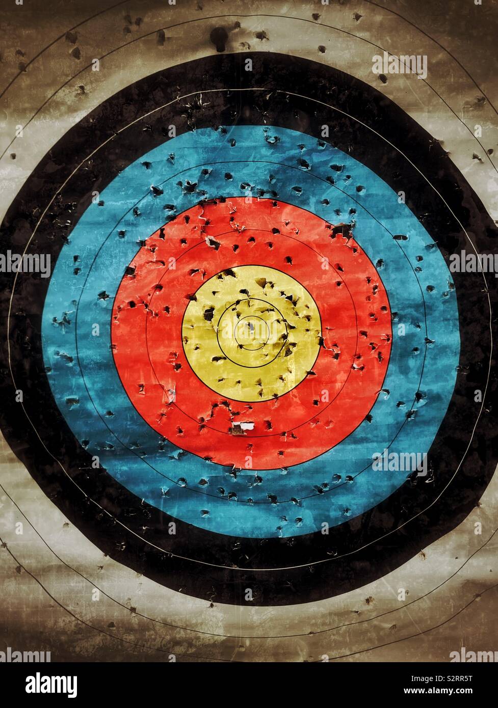 A well used archery target. Lots of holes means lots of arrows used! Some closer than others to the “sweet spot”! An image with multiple uses. Photo Credit - © COLIN HOSKINS. - Smartphone Captured Stock Image