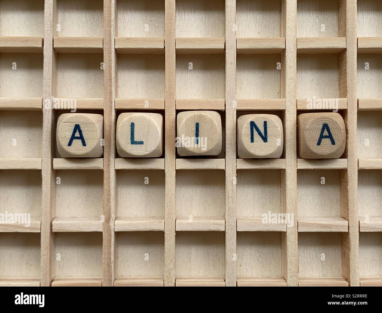 Alina, feminine given name composed with wooden cube dice letters - Smartphone Captured Stock Image