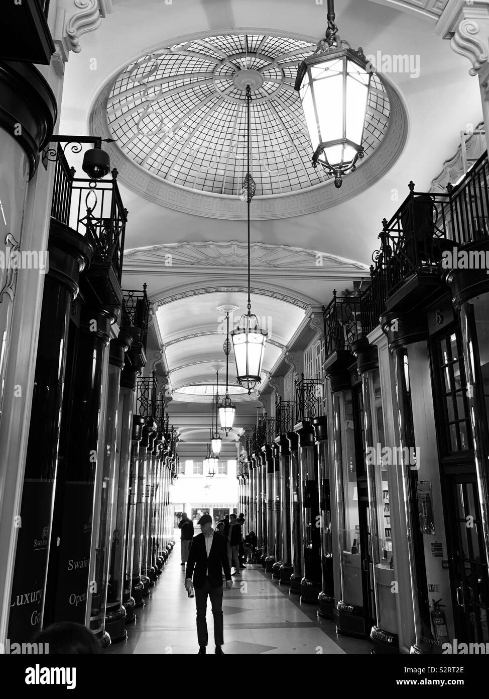 Black and white photo of Piccadilly Arcade with people and shops in west end London, England. Stock Photo