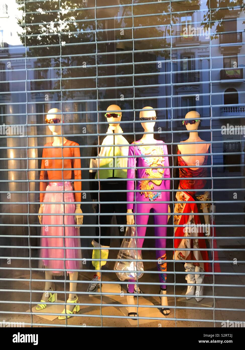 Four mannequins in the shop window of a closed shop. - Smartphone Captured Stock Image