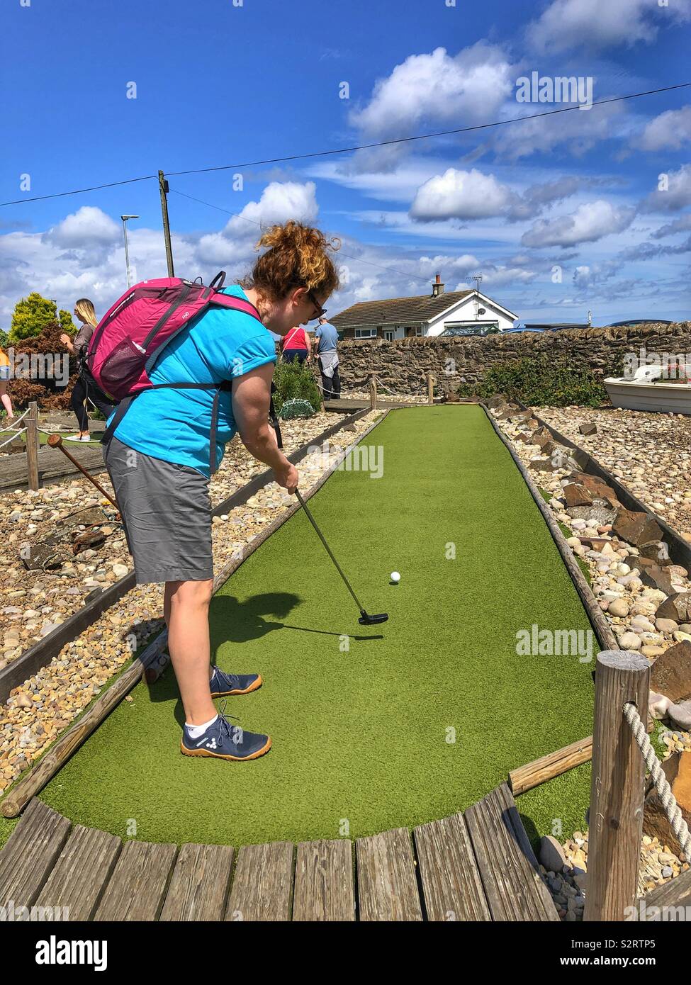 Woman playing mini golf at Seahouses Northumberland Stock Photo