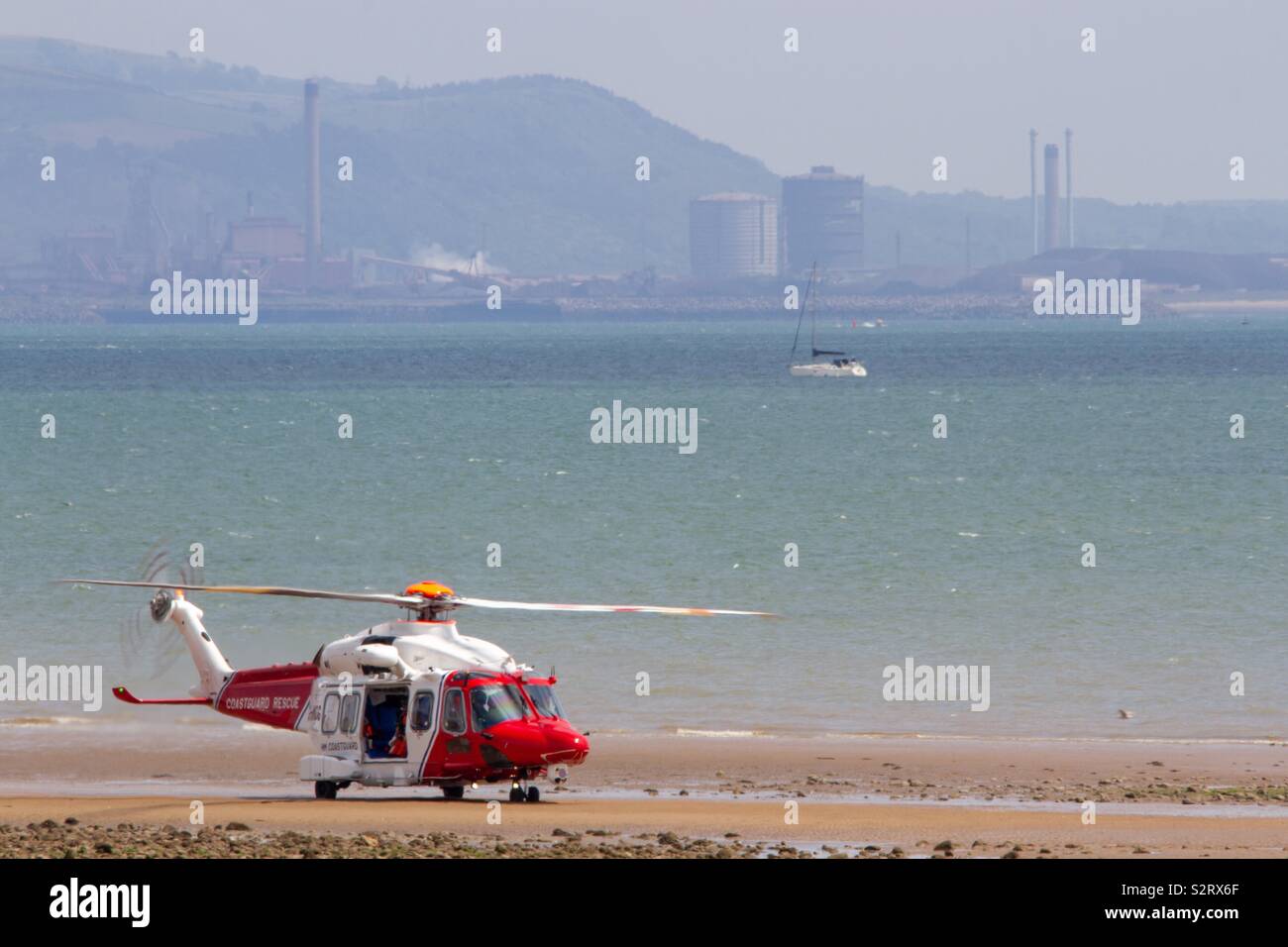 Coast guard landing on beach with an industrial backdrop - Smartphone Captured Stock Image