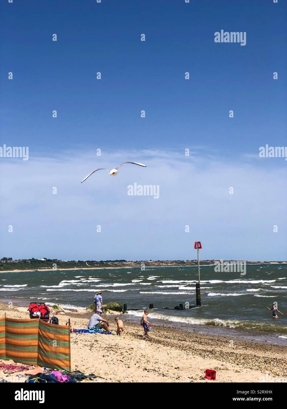Holidaymakers on Avon Beach at Mudeford, Christchurch in Dorset, UK on a hot summer day. - Smartphone Captured Stock Image