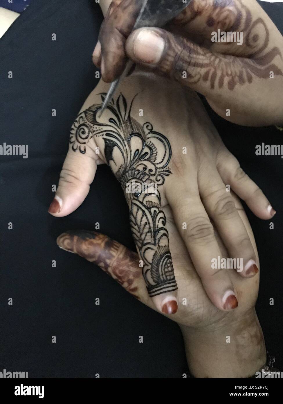 Henna painting with black dye (peacock). May cause severe allergic reaction Stock Photo