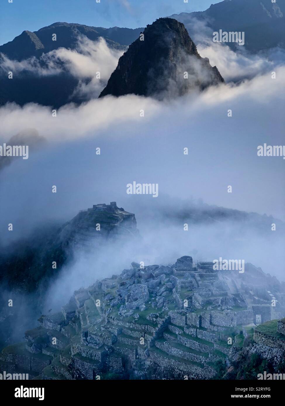 Cloud shrouds Machupicchu Machu Picchu and Huayna Picchu Wayna Pikchu at sunrise dawn. The Lost City of the Incas. - Smartphone Captured Stock Image