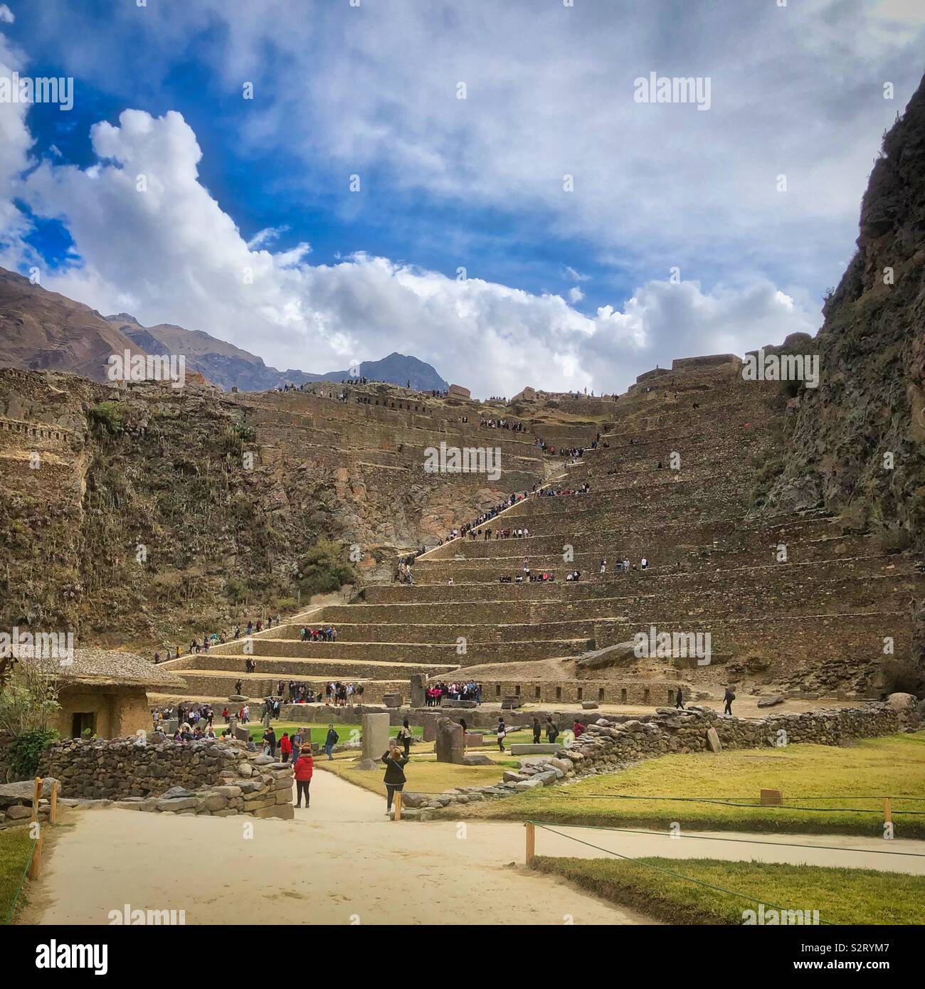 Tourists at Ollantaytambo Incan ruins historical site, Perú Peru. The people give a sense of scale on the massive terracing. - Smartphone Captured Stock Image