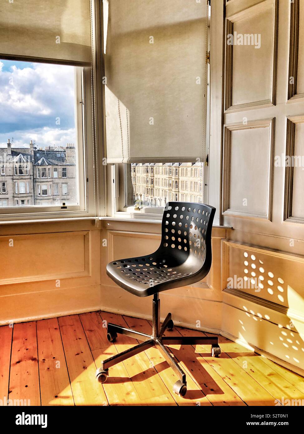 Desk chair bathed in evening sun - Smartphone Captured Stock Image