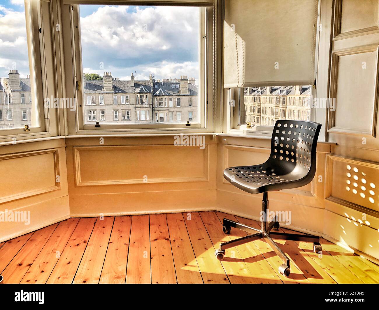 Desk chair bathed in evening sunlight - Smartphone Captured Stock Image
