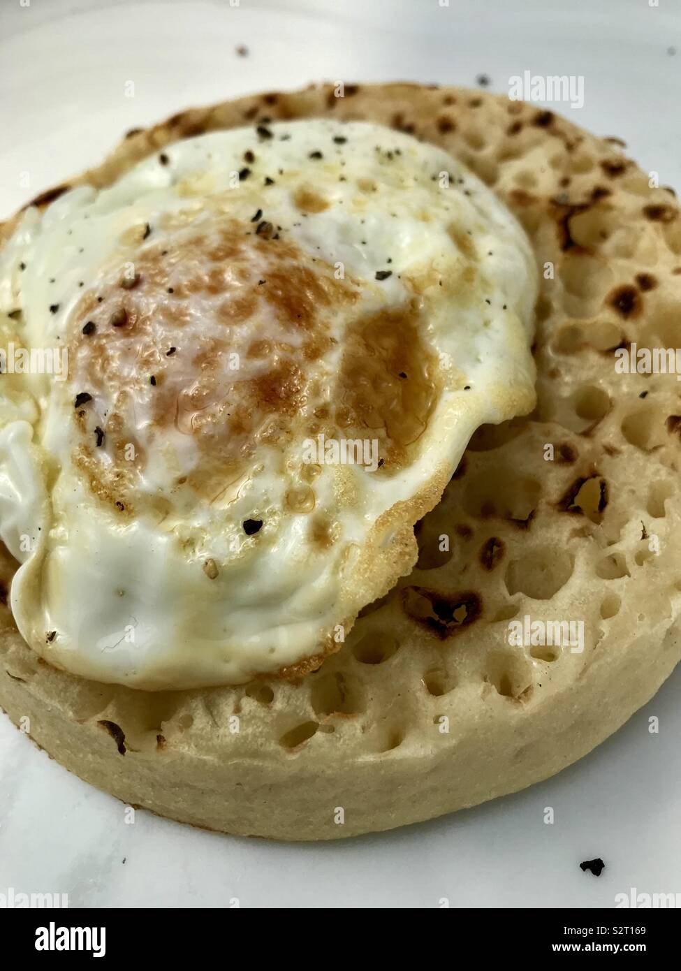 Breakfast Crumpet egg and cracked pepper Stock Photo