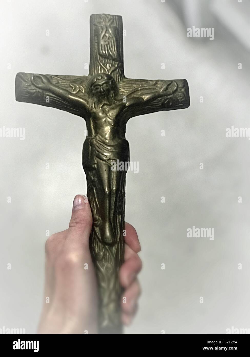 A crucifix - a woman holding a cross of Jesus in her hand. Stock Photo