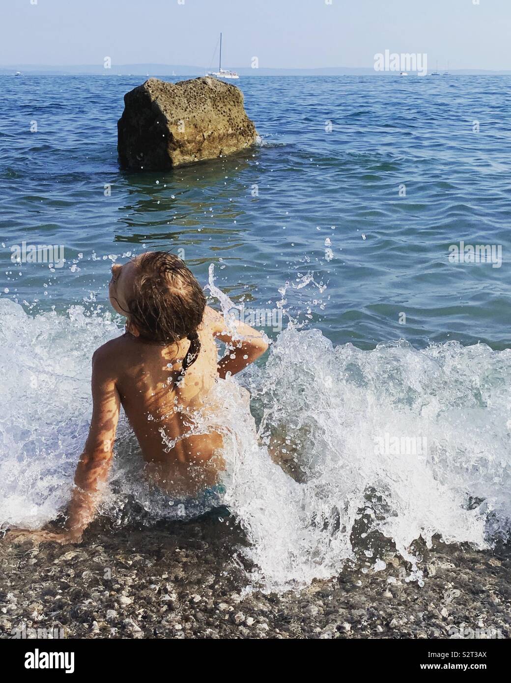 Girl playing with waves on sea shore. - Smartphone Captured Stock Image