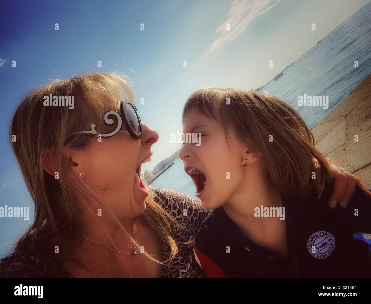 Mother and daughter playing like lions. - Smartphone Captured Stock Image