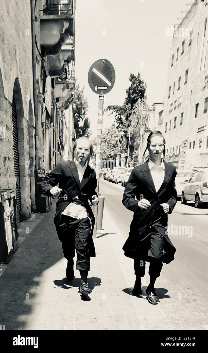Orthodox Jewish men running in a street in Jerusalem. - Smartphone Captured Stock Image