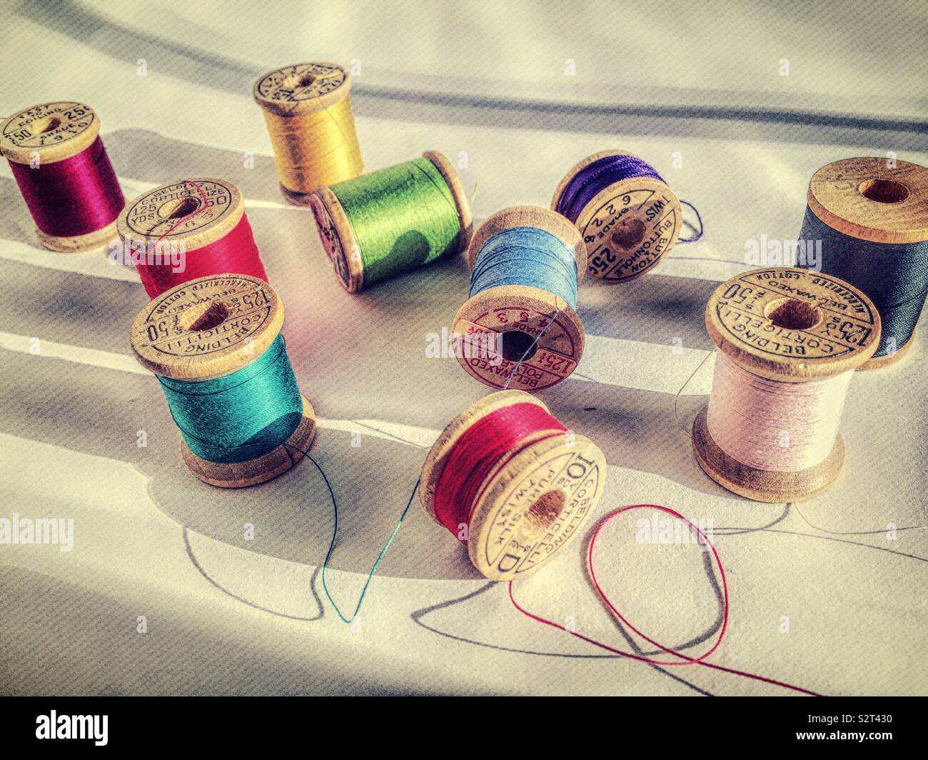 Detail of vintage wooden spoons of multi colored thread on a white background - Smartphone Captured Stock Image