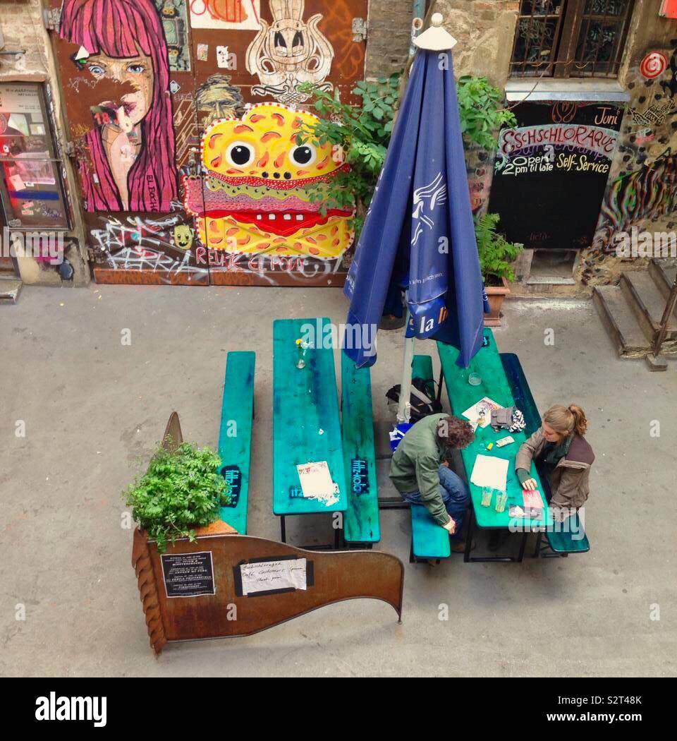 Couple sitting in a cafe in Berlin with street art - Smartphone Captured Stock Image