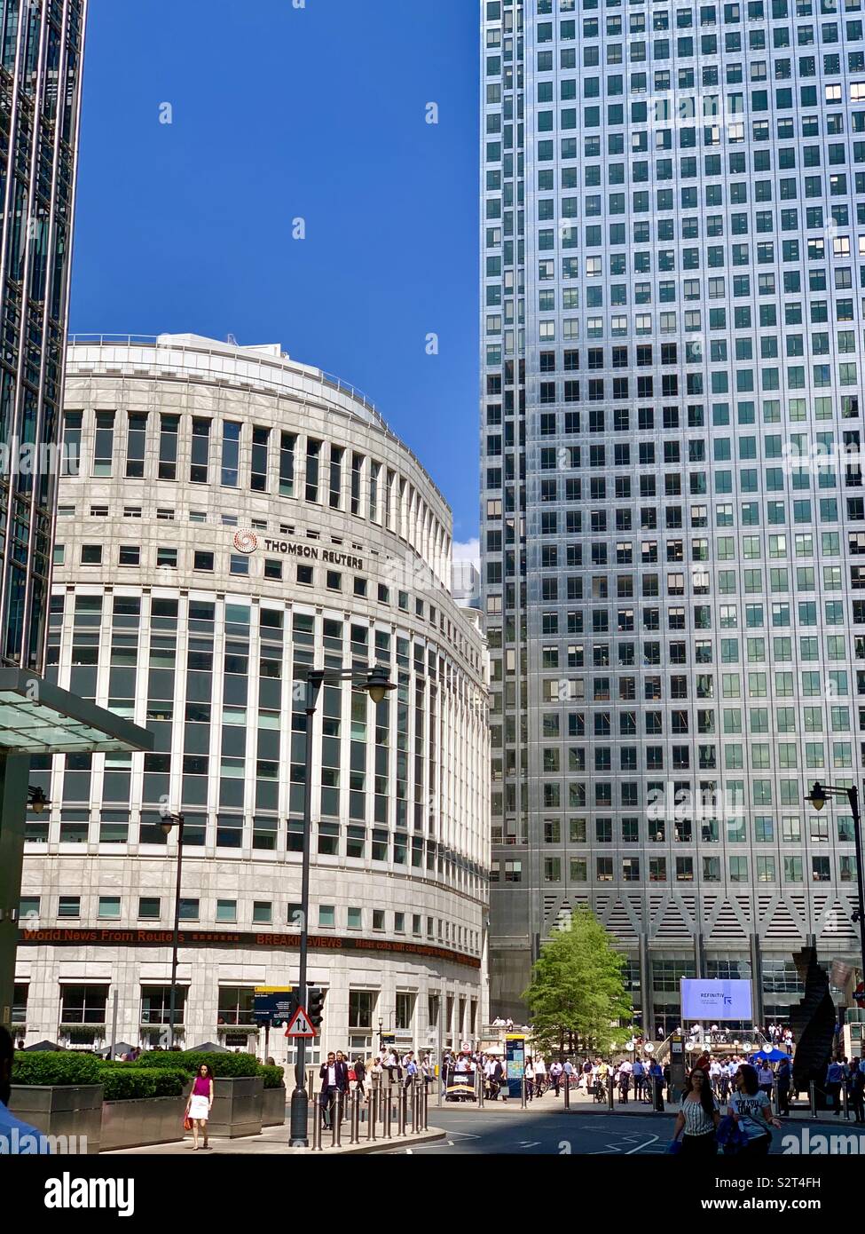 London, UK: One Canada Square towers over the Thomson Reuters building at Reuters Plaza, Canary Wharf. Stock Photo