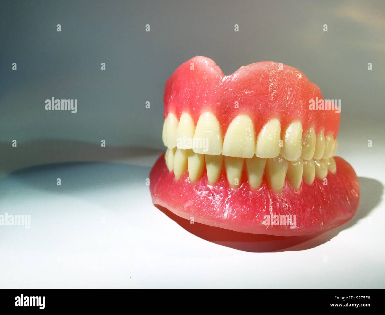 Close up of a brand new unused set of dentures on white background - Smartphone Captured Stock Image