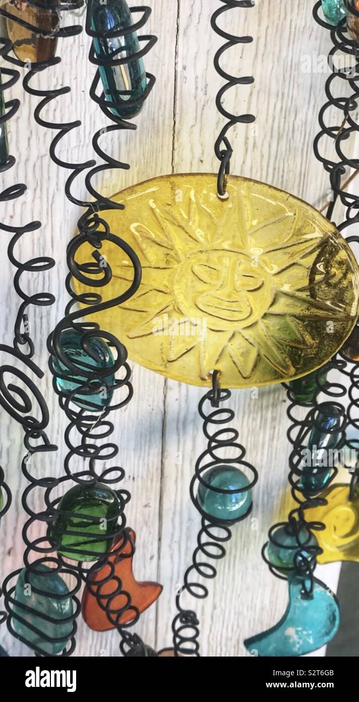 Chime with glass sun, metal swirls, moons, balls, yellow, blue, green red Stock Photo