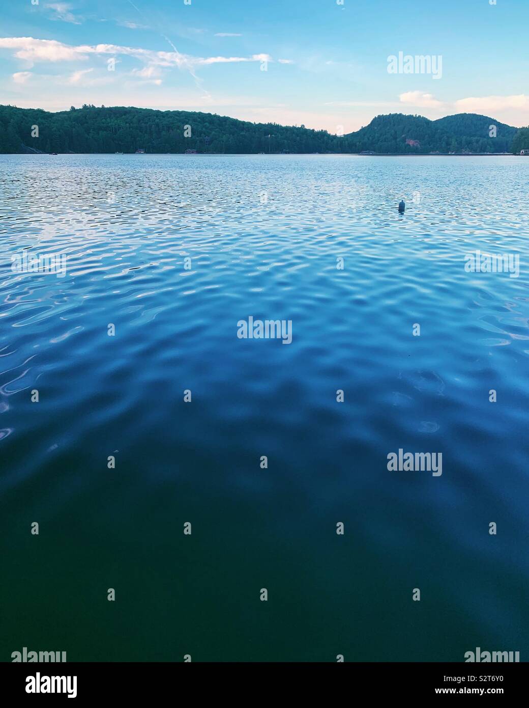 A buoy floats in the waters of Lake of Bays in northern Ontario Canada. July 2019 - Smartphone Captured Stock Image