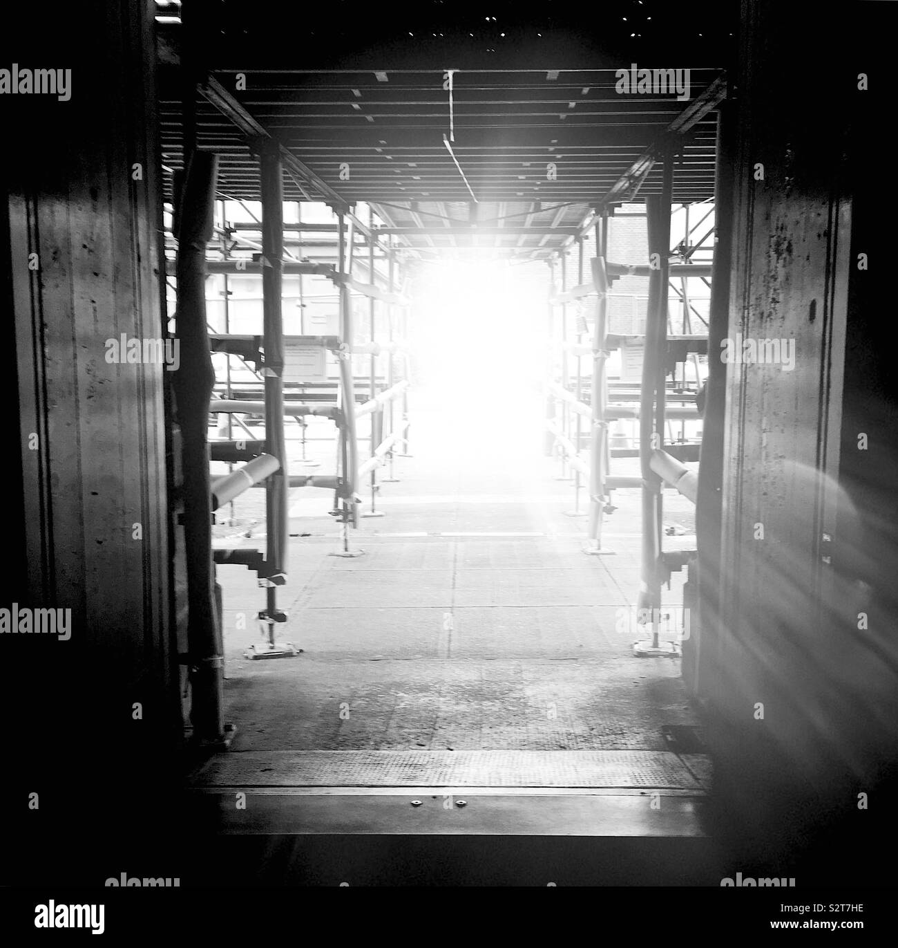 Sunflare through open doors and scaffolding Stock Photo
