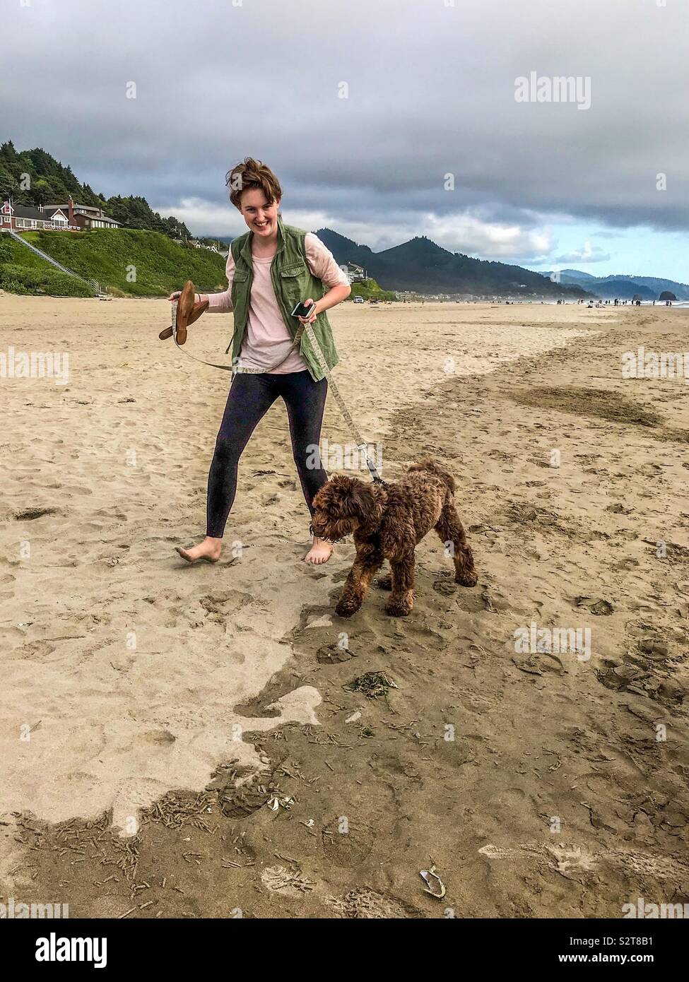 Woman walks her dog on Cannon Beach in July - Smartphone Captured Stock Image
