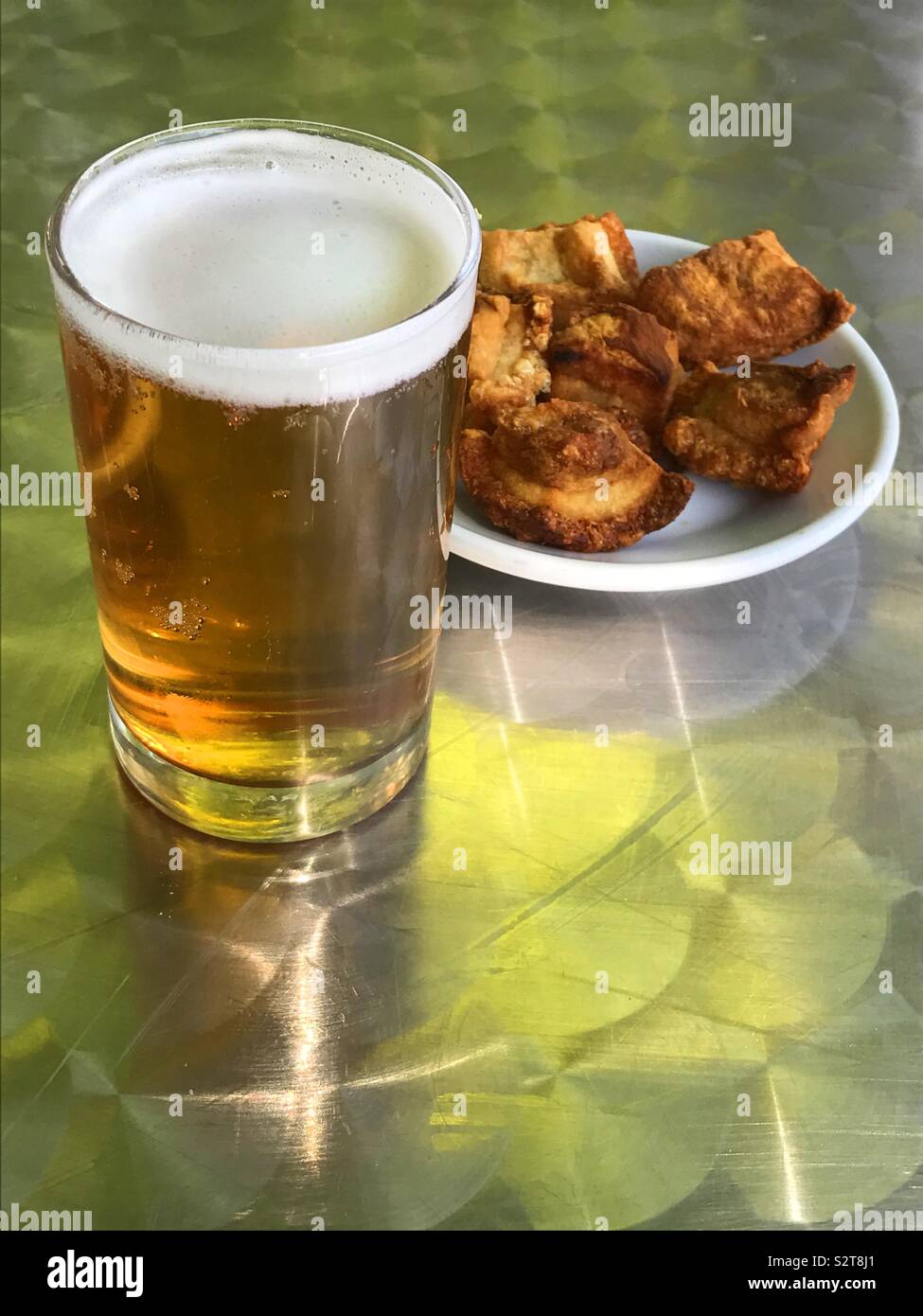 Glass of beer with torreznos serving as tapa. Spain. - Smartphone Captured Stock Image