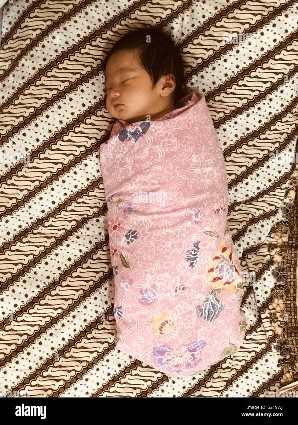 Asian newborn baby wrap in Batik. Stock Photo