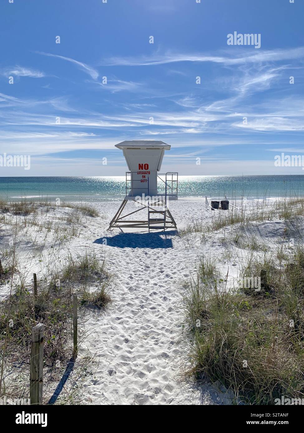 Lifeguard stand on beach with white sand, view of water and blue skies Stock Photo