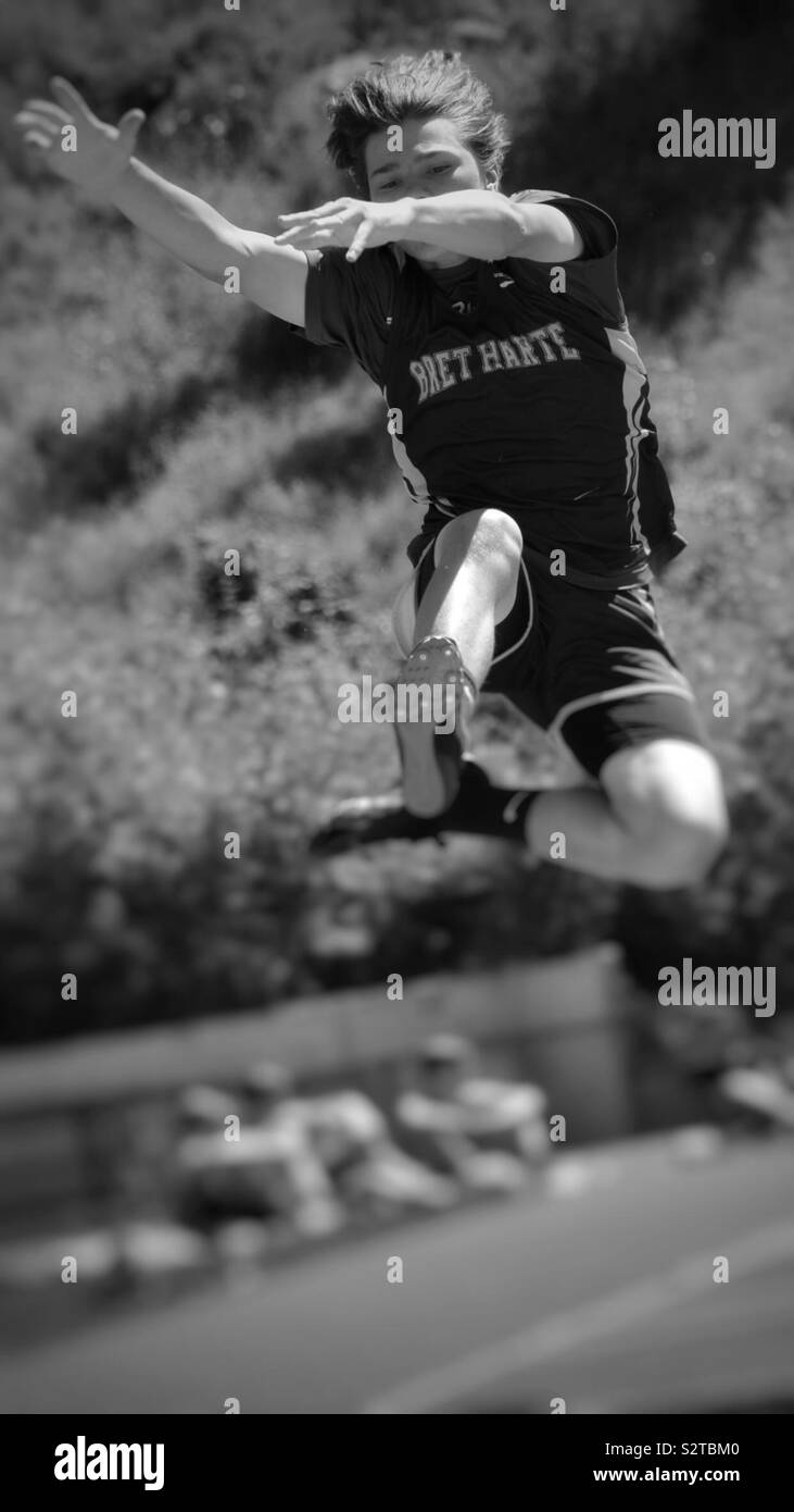 High school student jumping in air for long jump Stock Photo