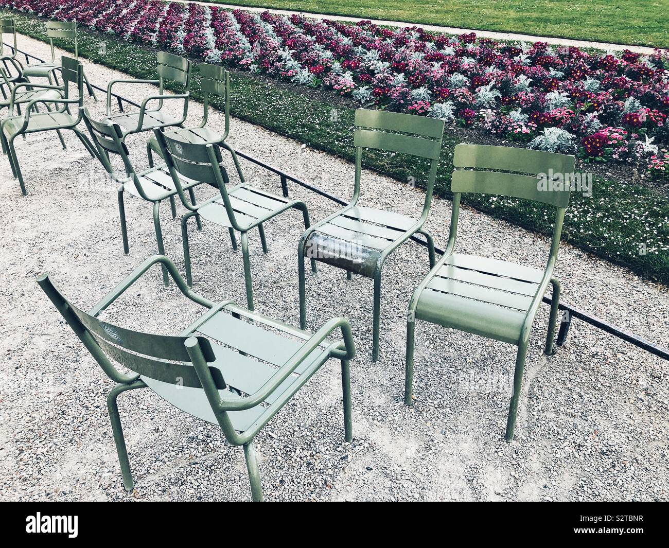Empty chairs and freshly planted flowers in Jardin du Luxembourg, also