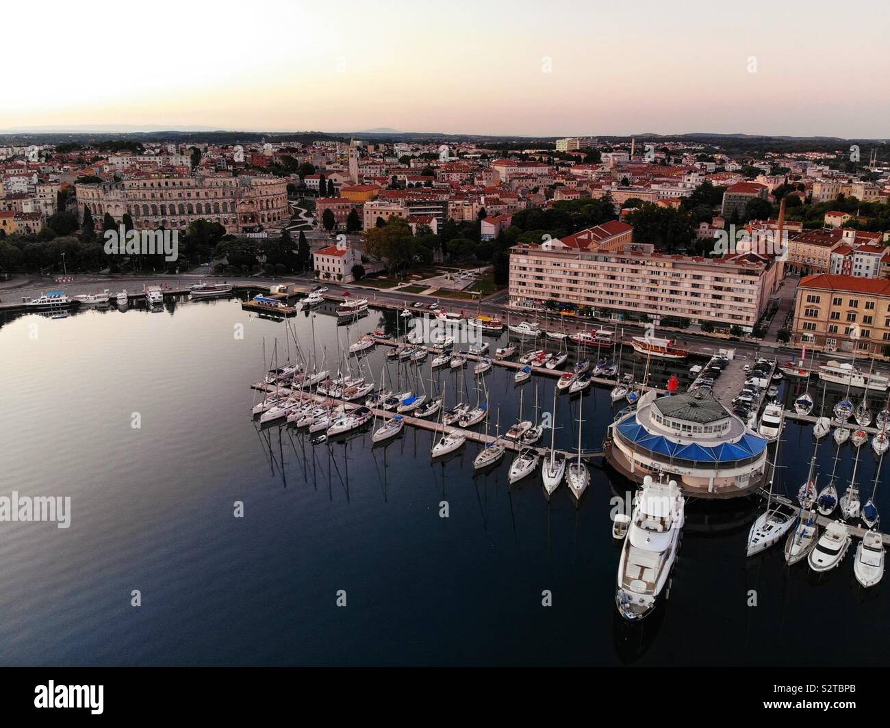 Aerial image of Pula in Croatia with the harbour and colosseum at sunrise. Stock Photo