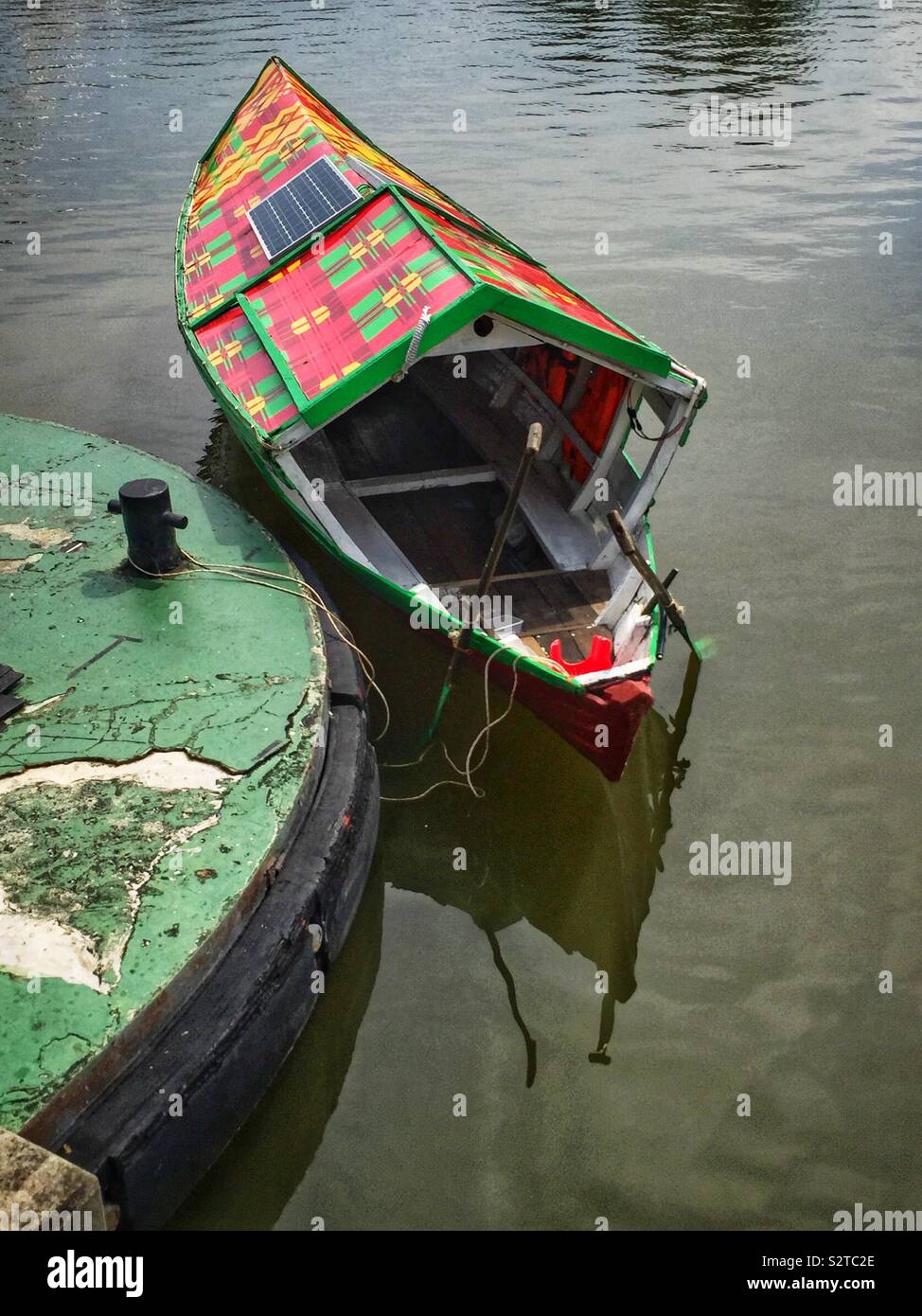 A traditional Malay sampan, modernised with solar panels for an electric motor, used to ferry people across the Sarawak River, Kuching, Sarawak, Malaysia - Smartphone Captured Stock Image