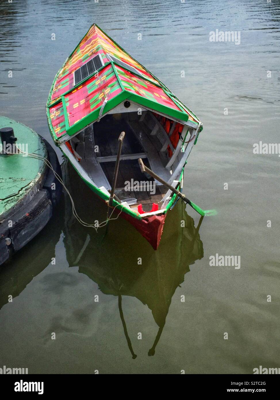 A traditional Malay sampan, modernised with solar panels for an electric motor, used to ferry people across the Sarawak River, Kuching, Sarawak, Malaysia - Smartphone Captured Stock Image