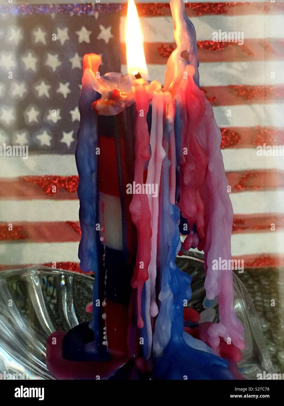 Red white and blue candle burning down in front of an American flag - Smartphone Captured Stock Image