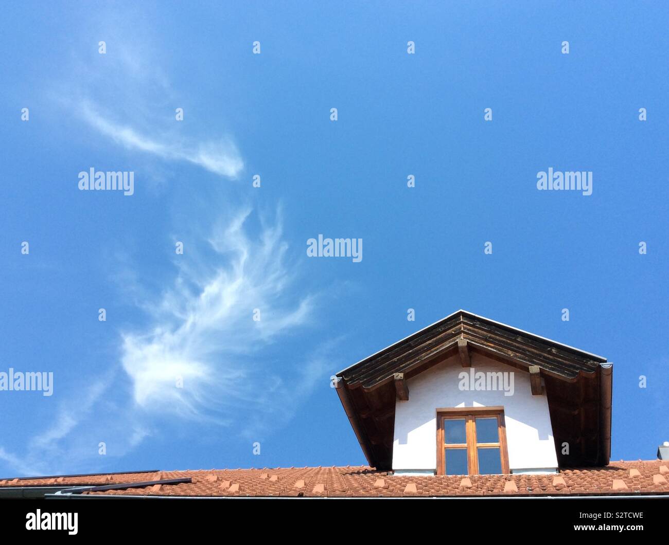 Cirrus cloud above dormer of a traditional Bavarian farmhouse and perfekt blue sky Bavaria, Germany, Europe Stock Photo