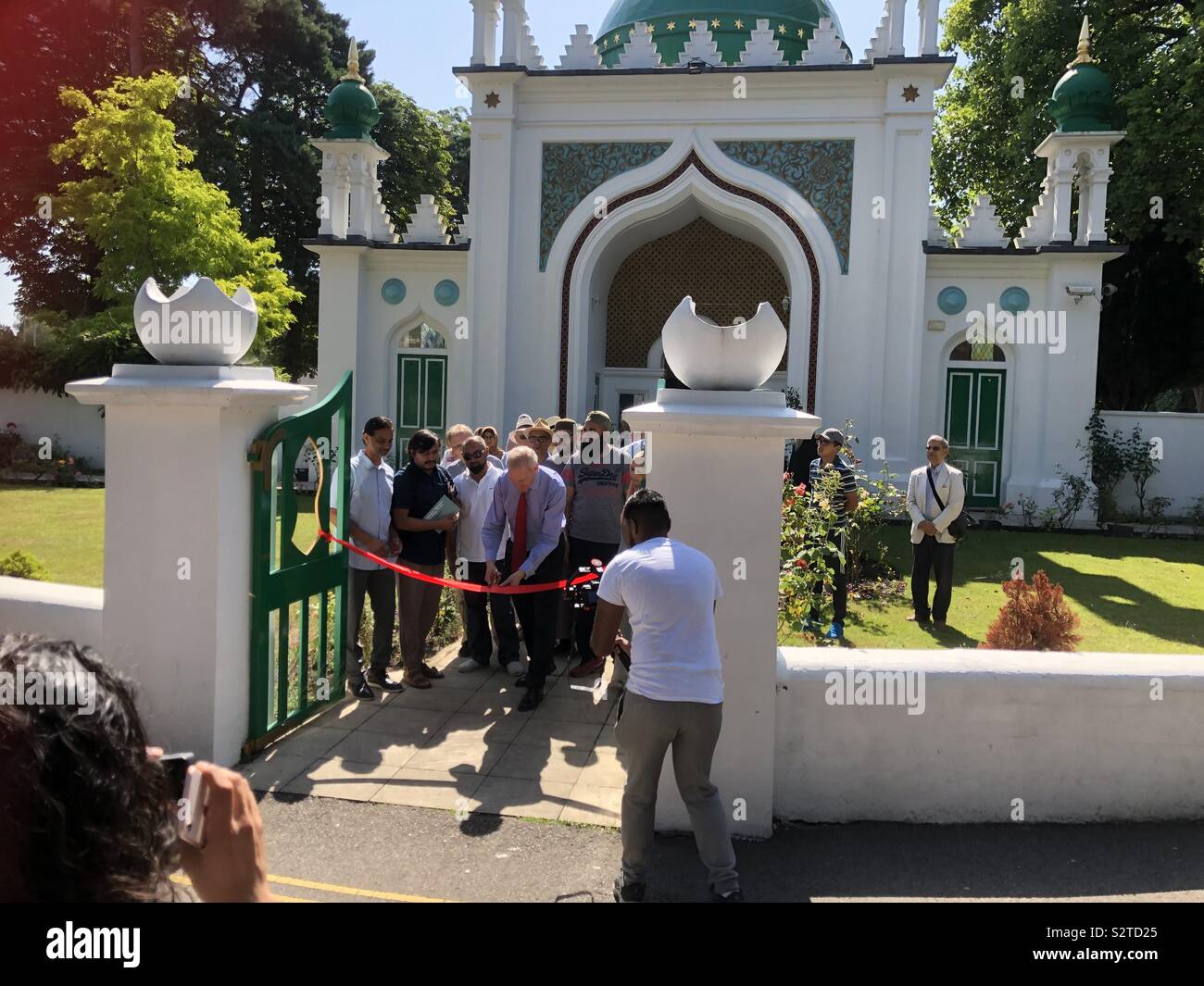 Sir Laurie Magnus (Chairman of Historic England) cuts the ribbon at Woking Mosque to officially open the first British Muslim Heritage Trail by cutting the ribbon. Stock Photo