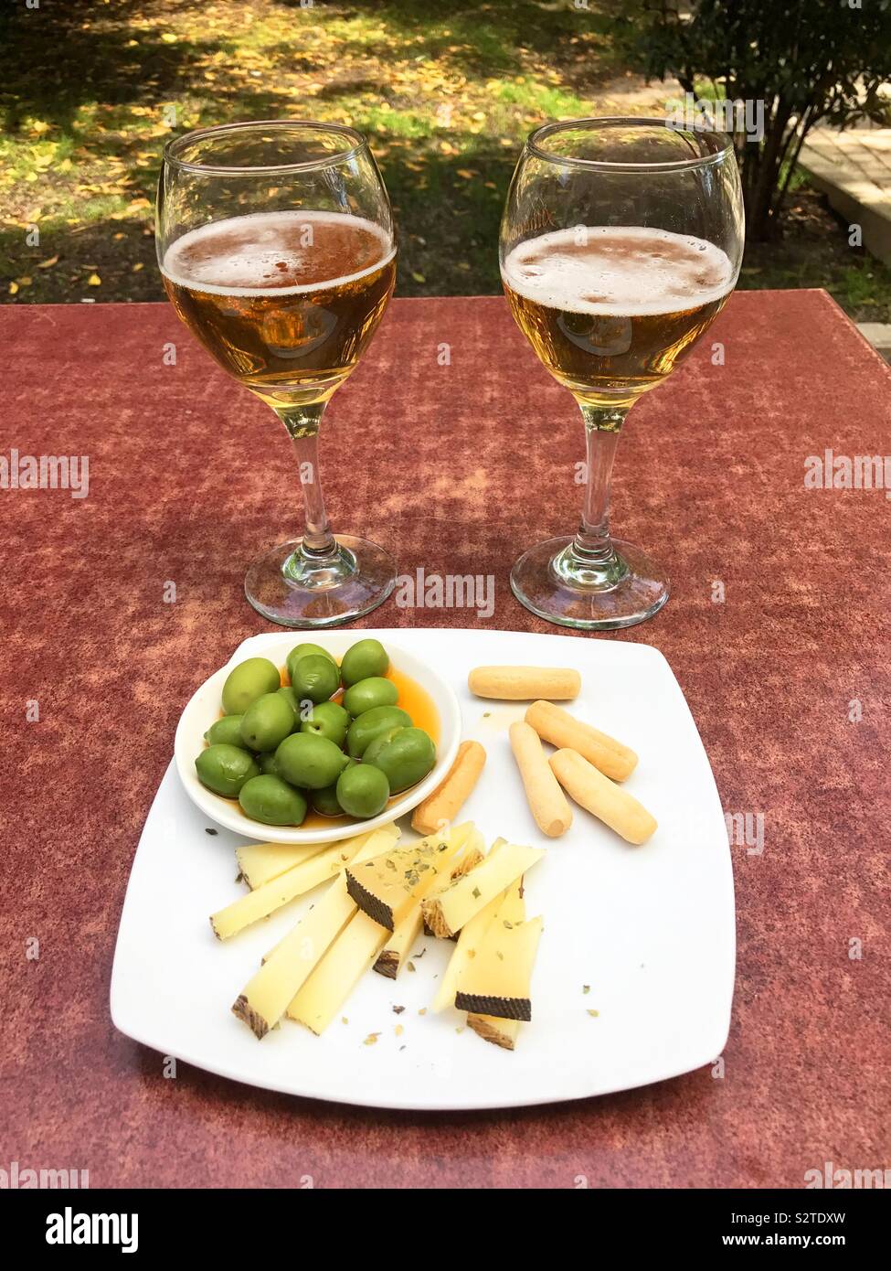 Two glasses of beer with cheese and green olives as tapa. Spain - Smartphone Captured Stock Image