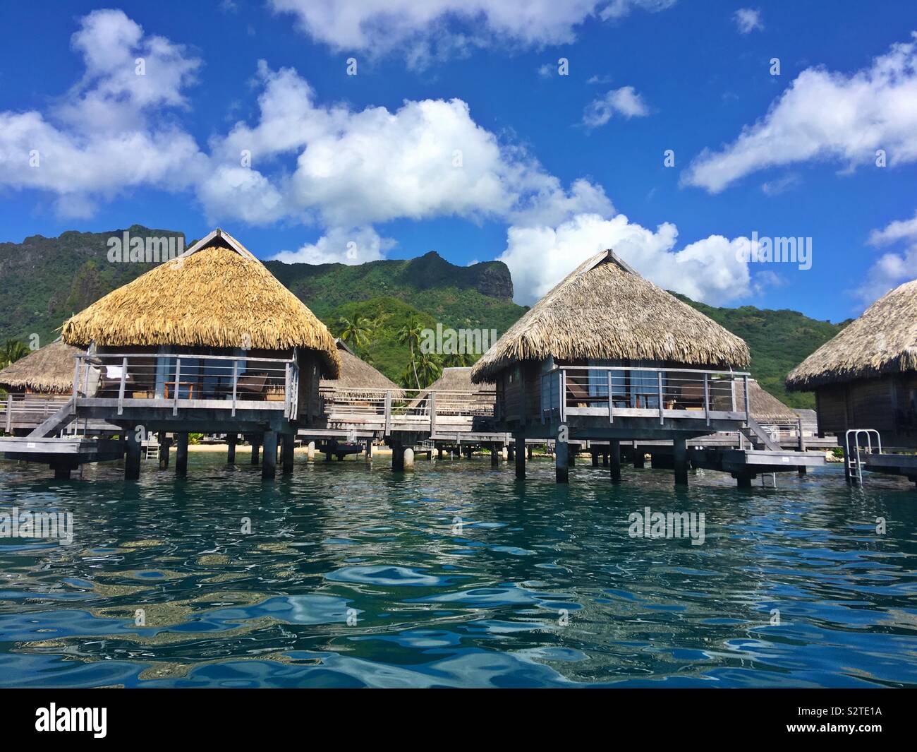 An water bungalows at a resort on Moorea, French Polynesia as seen from the lagoon - Smartphone Captured Stock Image