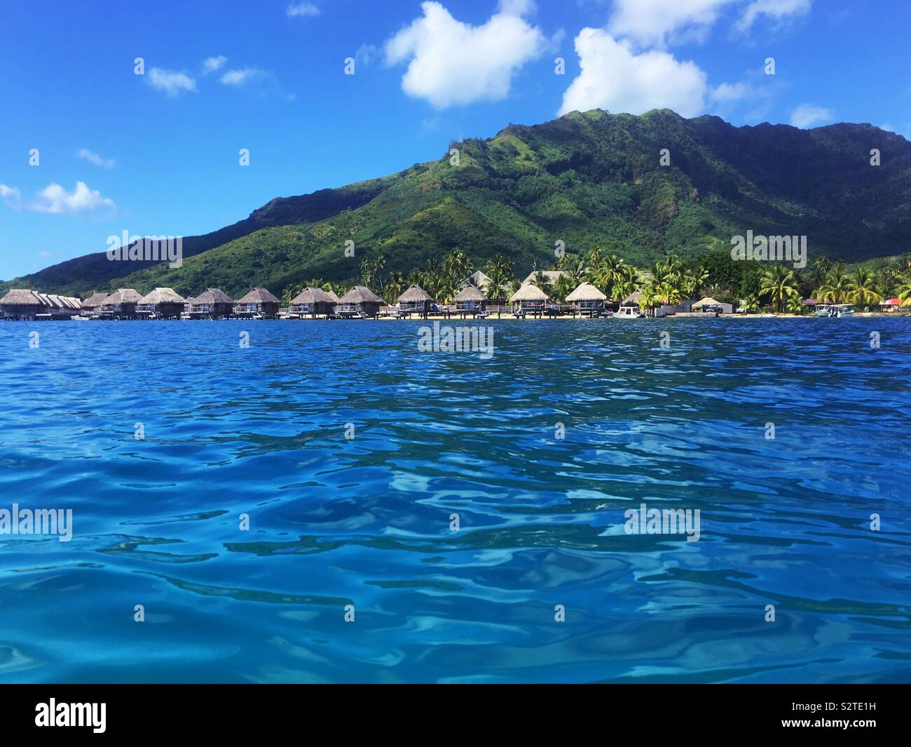 A luxury resort with overwater bungalows on Moorea, French Polynesia as seen from the lagoon - Smartphone Captured Stock Image