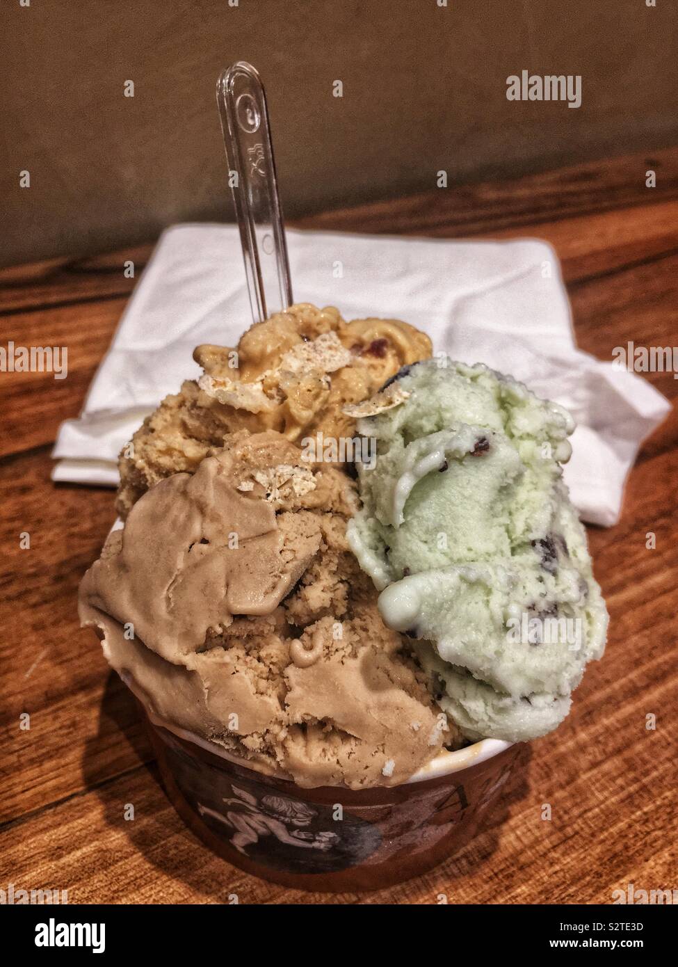 Large cup full of delicious caramel, mint chocolate chip, and hazelnut gelato. Stock Photo