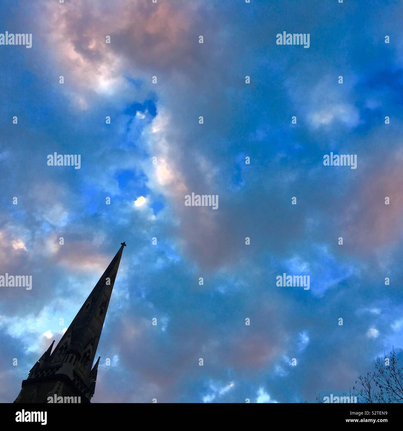 Cathedral spire with sunset clouds filling the sky - Smartphone Captured Stock Image