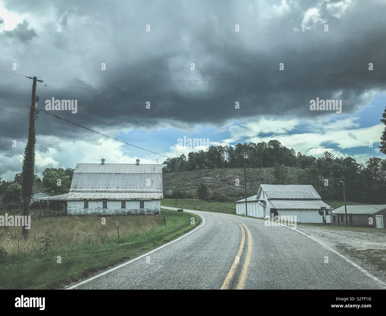 Farm on both sides of the road driving into the hills- summer - Smartphone Captured Stock Image