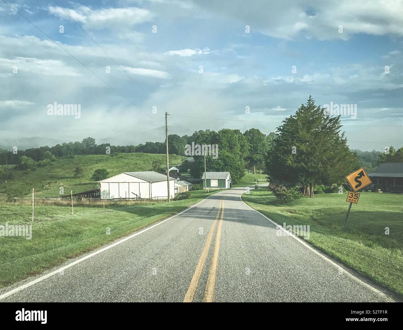 Farm and winding road ahead summer Stock Photo Alamy