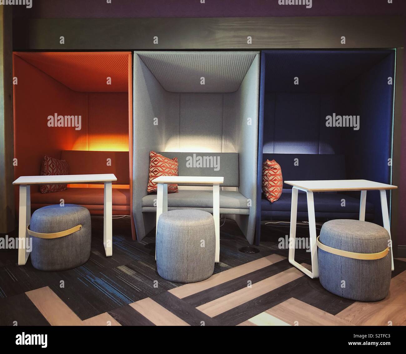 Modern, colorful work cubbies with desks and stools - Smartphone Captured Stock Image