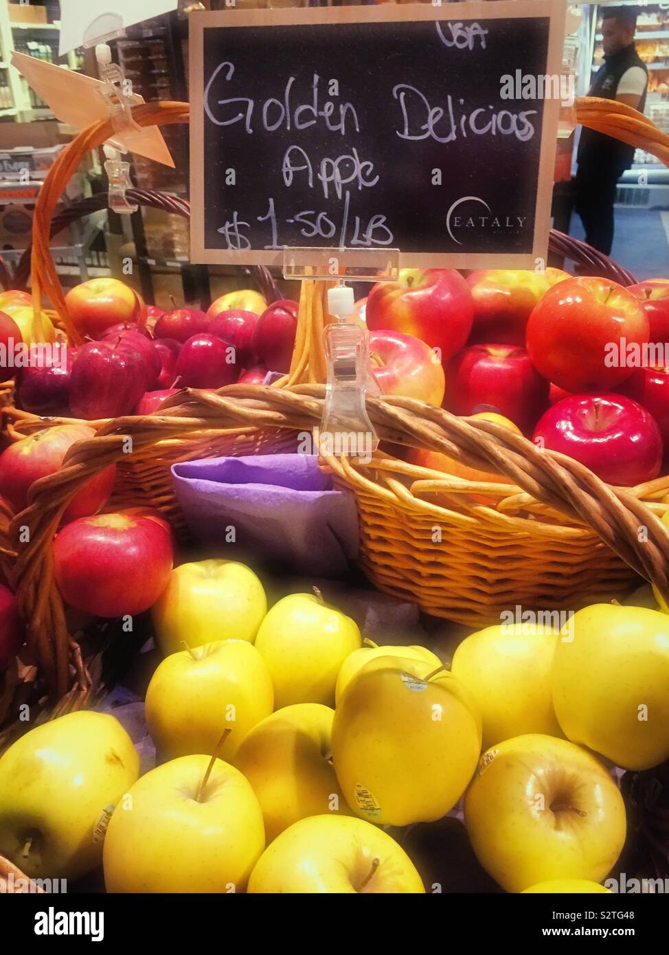 Wicker basket display of golden delicious apples at Eataly, NYC, USA Stock Photo