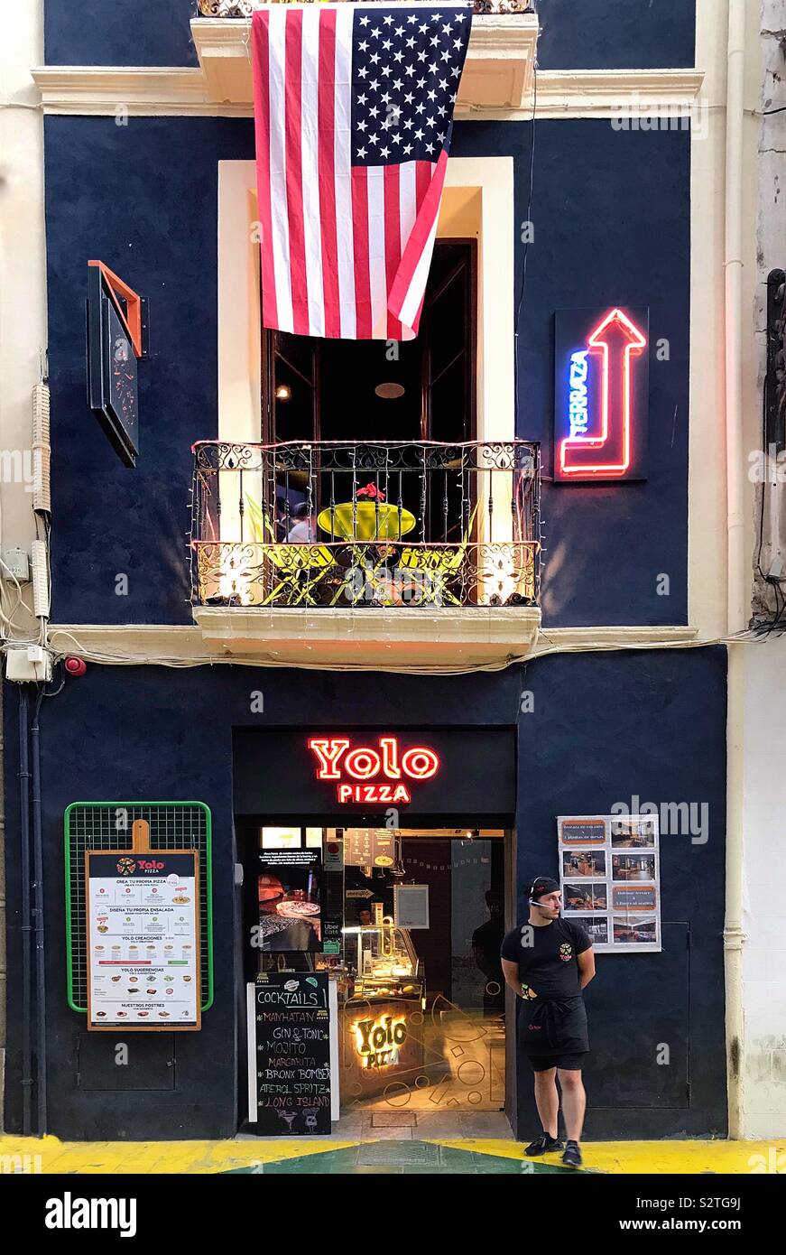 Yolo Pizza, Alicante, Spain where they fly the American flag outside the colourful restaurant facade. Stock Photo