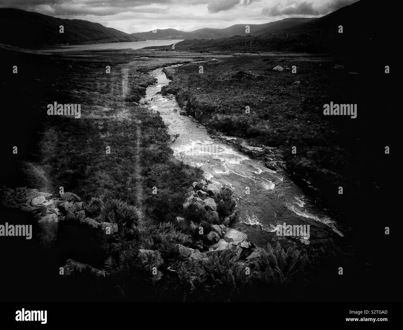 Black and white image of river gushing over rocks in wild landscape, Isle of Skye, Inner Hebrides, Scotland Stock Photo