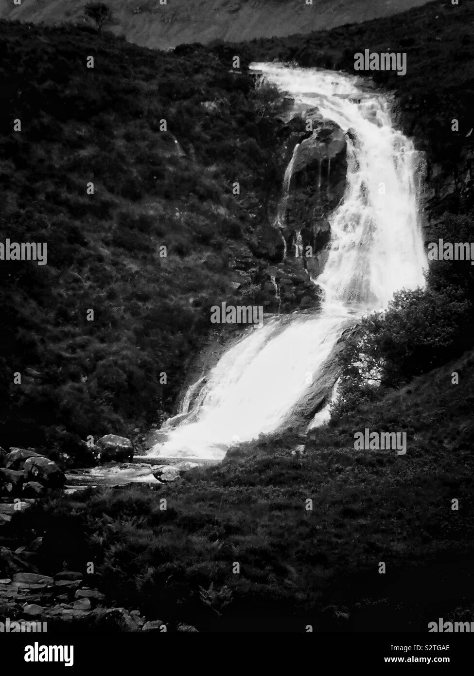 Black and white image of river gushing down mountain in wild remote landscape, Isle of Skye, Inner Hebrides, Scotland - Smartphone Captured Stock Image