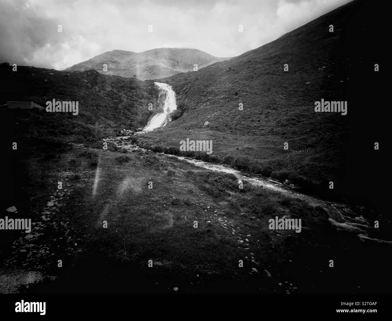 Atmospheric black and white image of river running through dramatic wild remote landscape, Isle of Skye, Inner Hebrides, Scotland - Smartphone Captured Stock Image